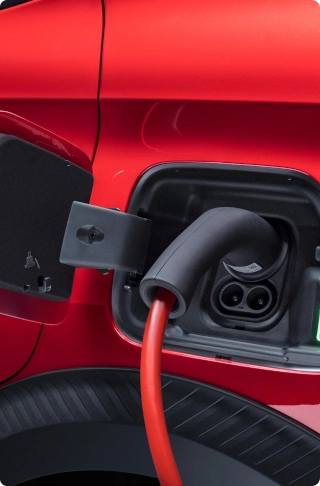 Close-up view of the Citroën ë-C3 Van charging port connected to a charging cable, highlighting electric mobility and convenient recharging.