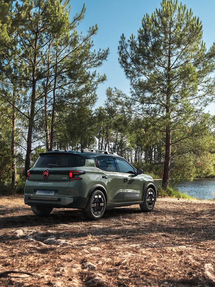 Rear three-quarter view Citroën ëC3 Aircross SUV shows LED signature, Advanced Comfort, family SUV on forest road