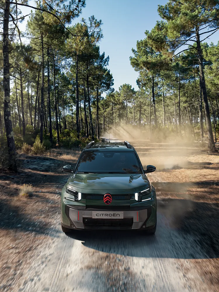 Aerial front view Citroën ëC3 Aircross SUV shows LED signature, Advanced Comfort, family SUV on forest trail