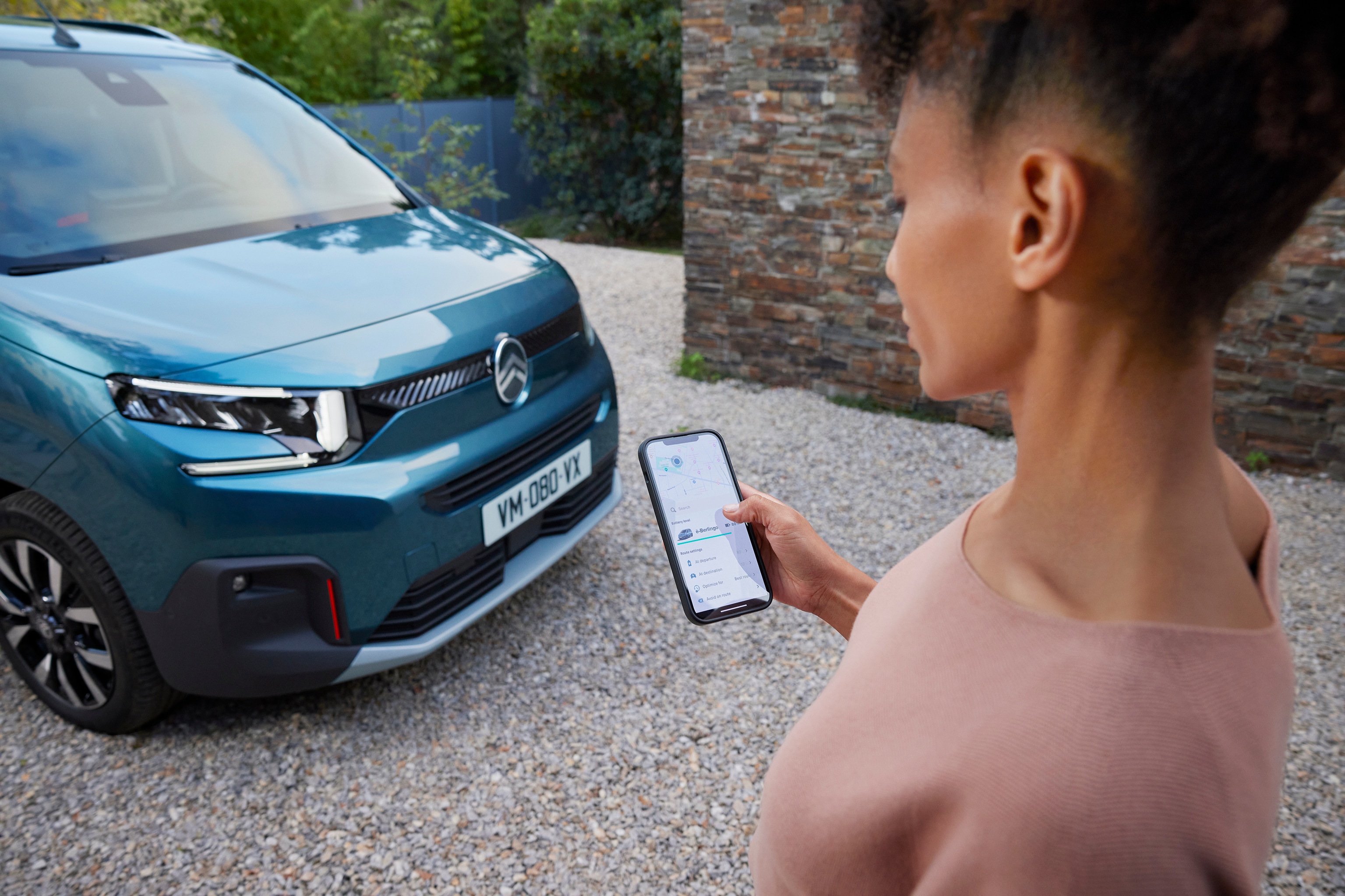 Woman looking at her MyCitroën app in front ë-Berlingo