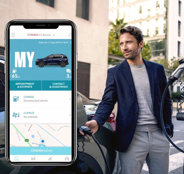 Citroen smartphone showing myCitroen app with man charging C 5 X behind