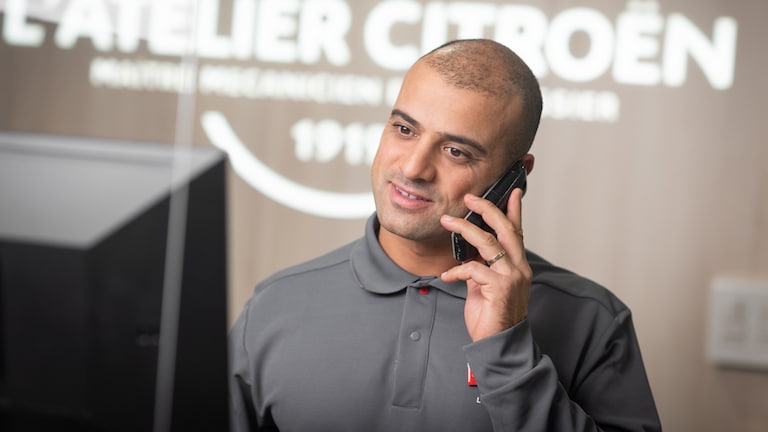 Citroen service advisor with telephone to his ear